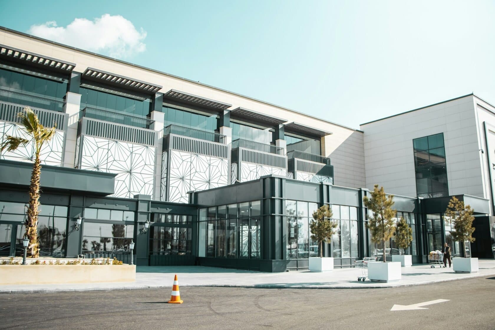 Modern two-story commercial building with a glass entrance on a sunny day
